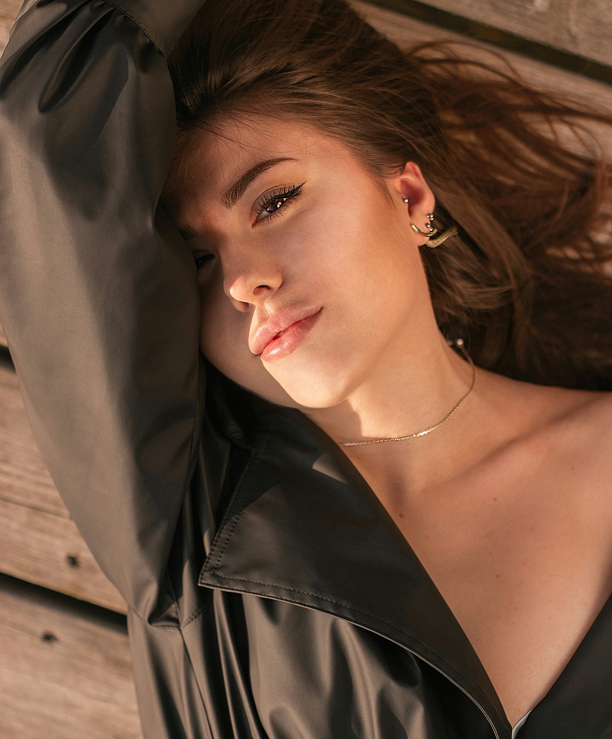 Woman relaxing with a serene expression outdoors.