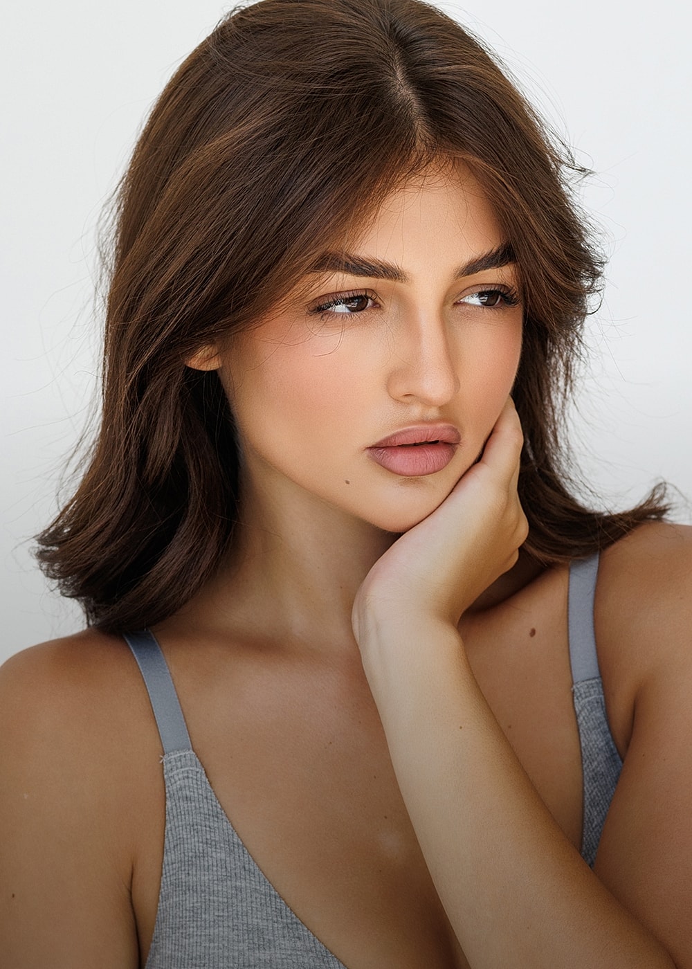 Model with soft makeup and thoughtful expression.