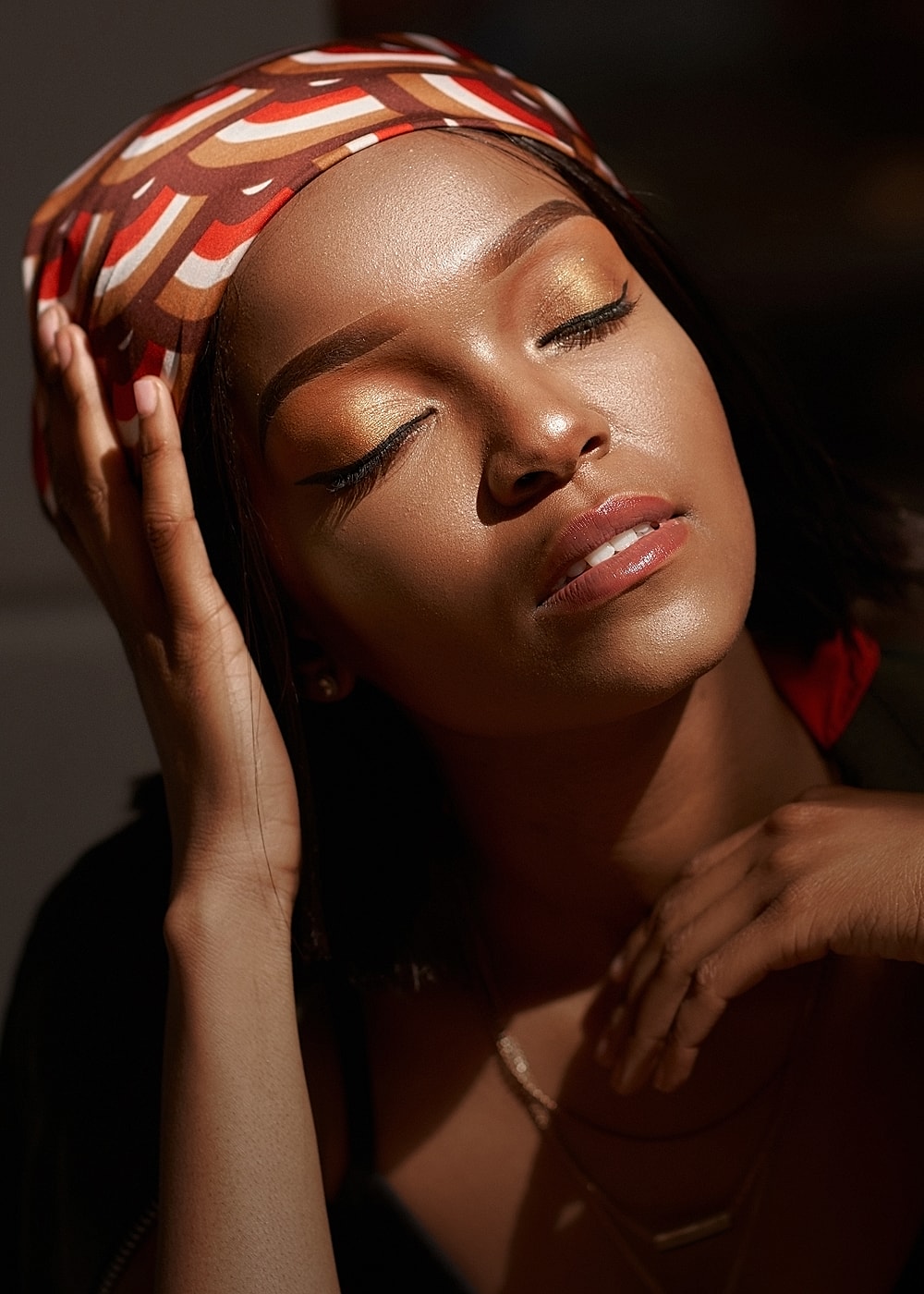 Woman with closed eyes and stylish headscarf.