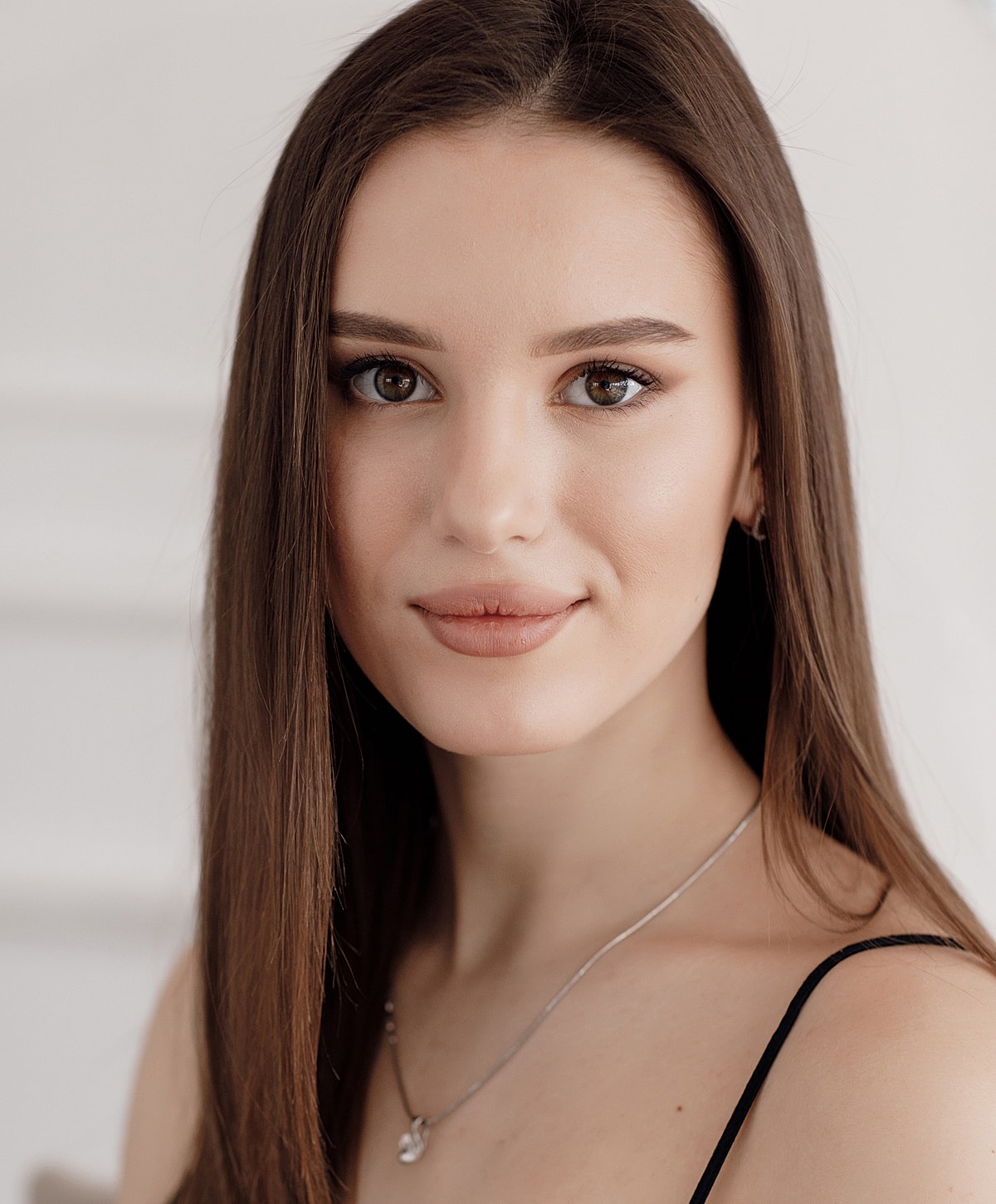 Young woman with long hair and subtle makeup.