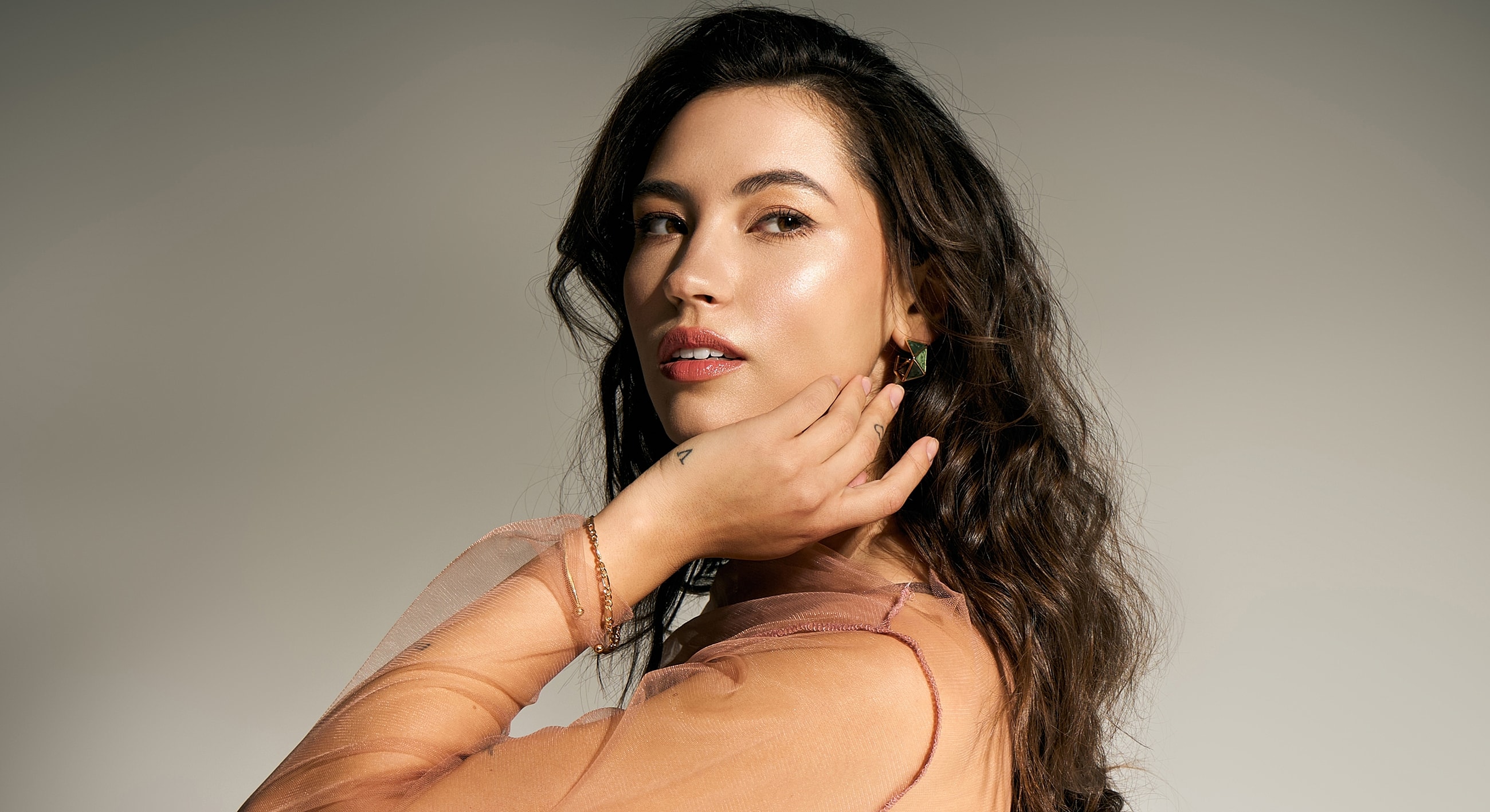 Woman with curly hair in soft lighting.